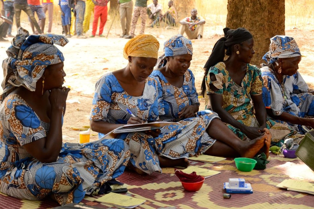 Groupe de femmes réuni sous un arbre pour une séance de crédit solidaire